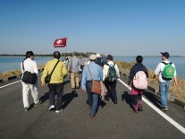 下宮橋を渡り、谷中湖の中を歩く一行
