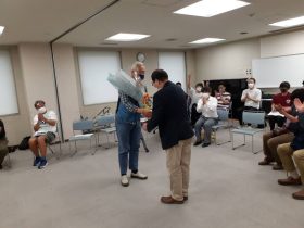 新会長中村亨さん（高31回）から前会長の長谷川博さん（高29回）へ花束贈呈