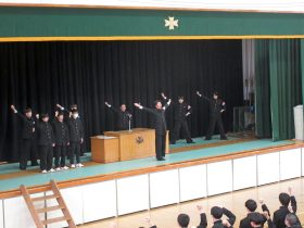 壇上は、囲碁部３名の全国大会出場者。応援指導部団長による校歌斉唱の様子